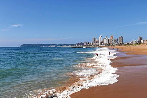 A beach with a body of water and a city